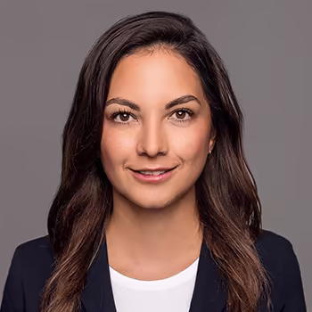 Bewerbungsfoto einer Frau mit dunklem Haar und schwarzem Blazer